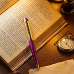 Open book with a pen, pocket watch, and paper on a wooden surface